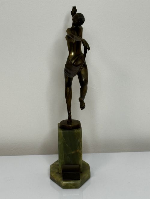 fig 3. An Art Deco bronze sculpture depicting a dancer with draped fabric, mounted on a green onyx pedestal base.