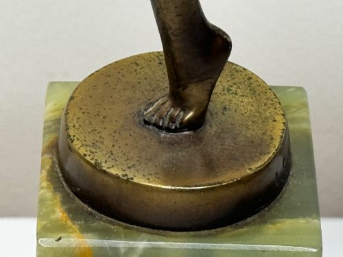 fig 6. An Art Deco bronze sculpture depicting a dancer with draped fabric, mounted on a green onyx pedestal base.