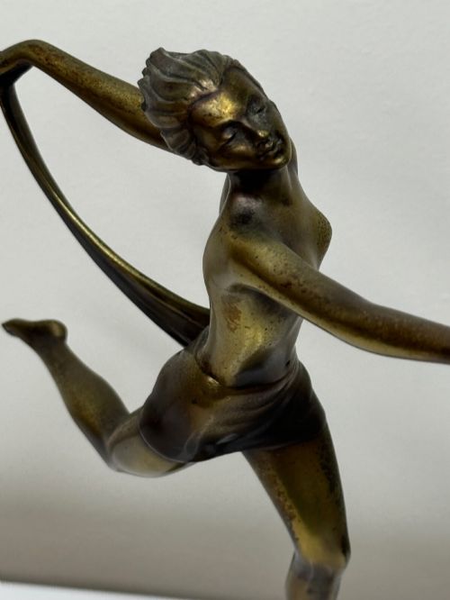 fig 9. An Art Deco bronze sculpture depicting a dancer with draped fabric, mounted on a green onyx pedestal base.