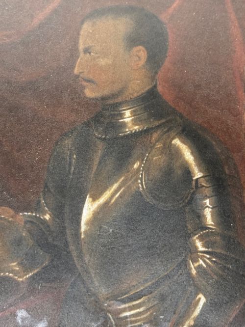 fig 4. An antique profile portrait painting of a man wearing full steel armour, set within an ornate gilded frame decorated with carved shell and scroll motifs.