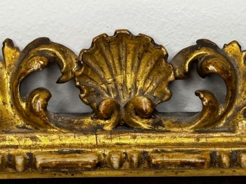 fig 8. An antique profile portrait painting of a man wearing full steel armour, set within an ornate gilded frame decorated with carved shell and scroll motifs.