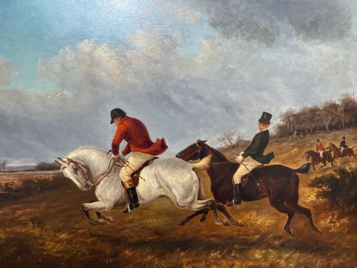 fig 2. An antique Victorian oil painting depicting horse riders in red hunting coats on grey and bay horses, housed within an ornate gilt frame.