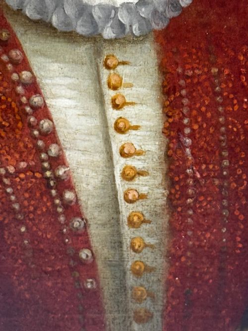 fig 11. An 18th-century oil portrait of a man in a black hat, ruff collar, and crimson doublet set inside a carved gold-gilded frame.