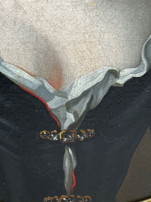 fig 5. An early 18th-century oil portrait of a young woman wearing a dark gown with slashed sleeves, presented in a square giltwood frame with an oval spandrel.