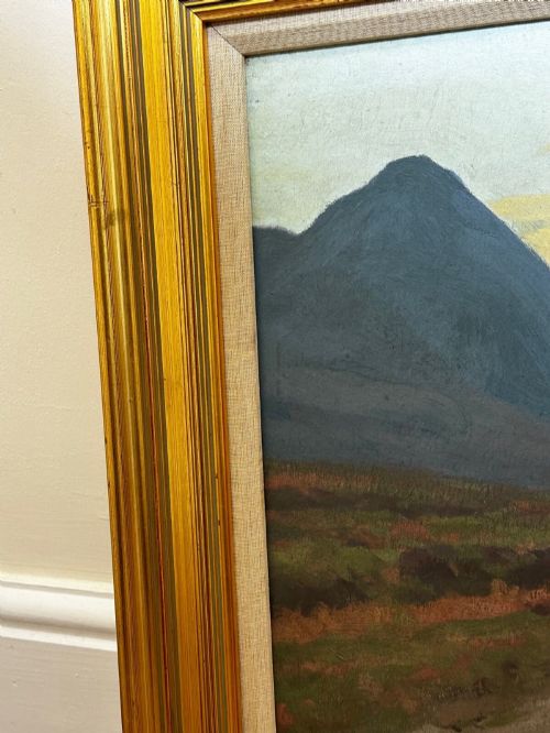 fig 6. An oil painting on canvas depicting a Scottish mountain landscape under a pale yellow sky, framed in a moulded gold frame with a linen inner slip.