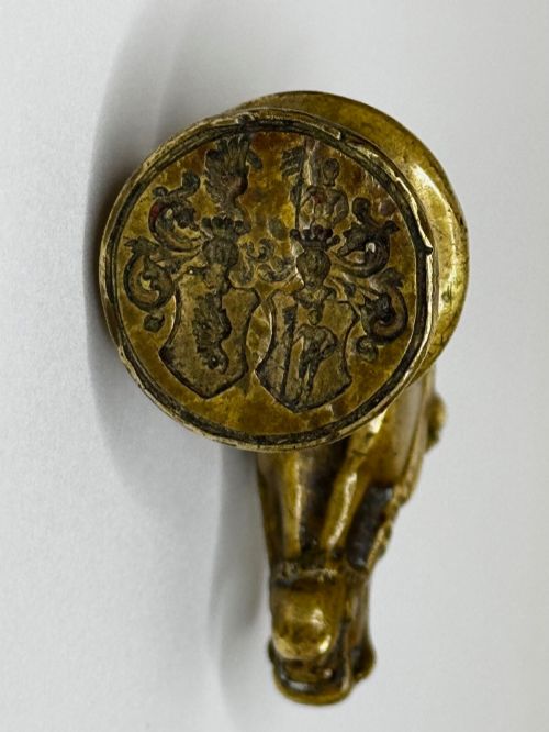 fig 3. A cast brass Georgian desk seal sculpted in the shape of a detailed horse head above a rounded pedestal with an engraved intaglio base.