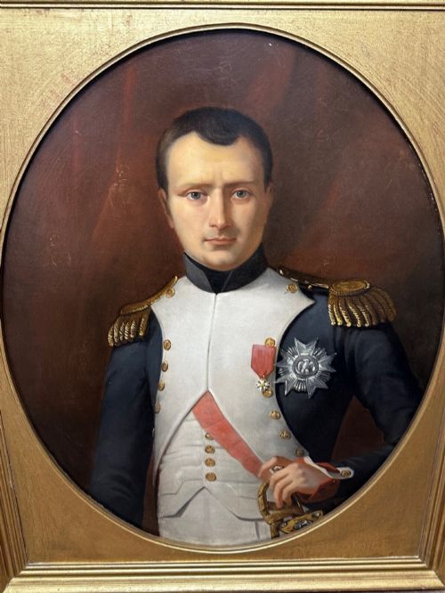 fig 1. A 19th-century oil painting depicting Napoleon I in a military uniform within an oval spandrel and a rectangular gilded frame.