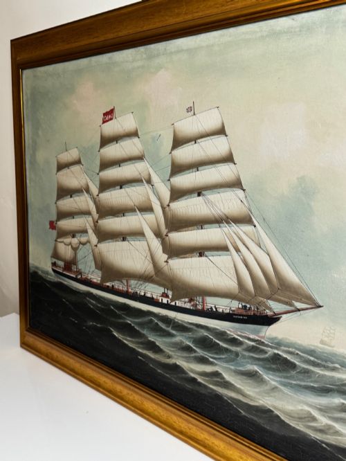 fig 8. A framed oil painting depicting a three-masted sailing ship navigating dark blue seas under a cloudy sky within a gold gilt frame.