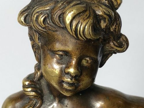 fig 2. A patinated bronze sculpture depicting a young girl carrying two large woven baskets on a rounded base.