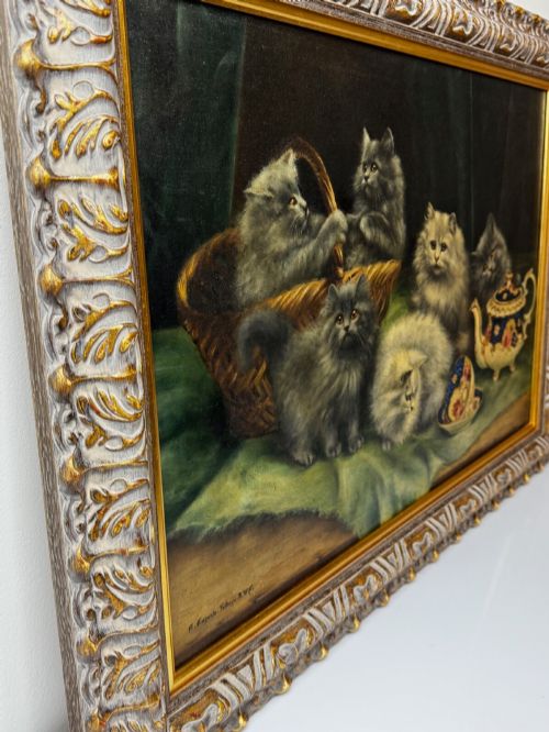 fig 8. An antique framed oil painting depicting five grey and cream Persian kittens positioned around a wicker basket and a floral porcelain teapot.