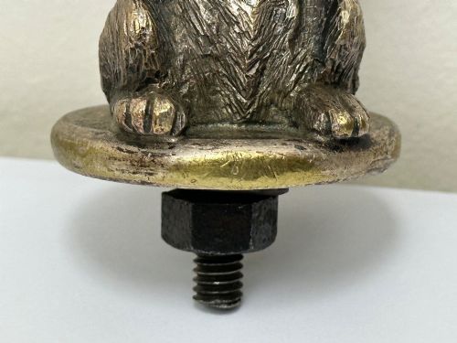 fig 3. A cast bronze car mascot depicting a Scottish Terrier sitting in a begging pose mounted on a small circular base with a threaded bolt.
