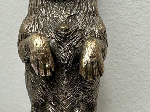 fig 10. A cast bronze car mascot depicting a Scottish Terrier sitting in a begging pose mounted on a small circular base with a threaded bolt.