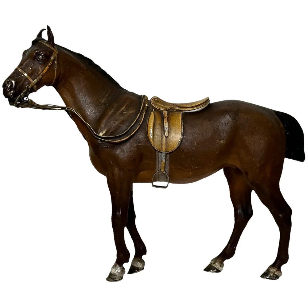 A Victorian cold-painted bronze figure depicting a standing bay hunter horse complete with detailed saddle and bridle.