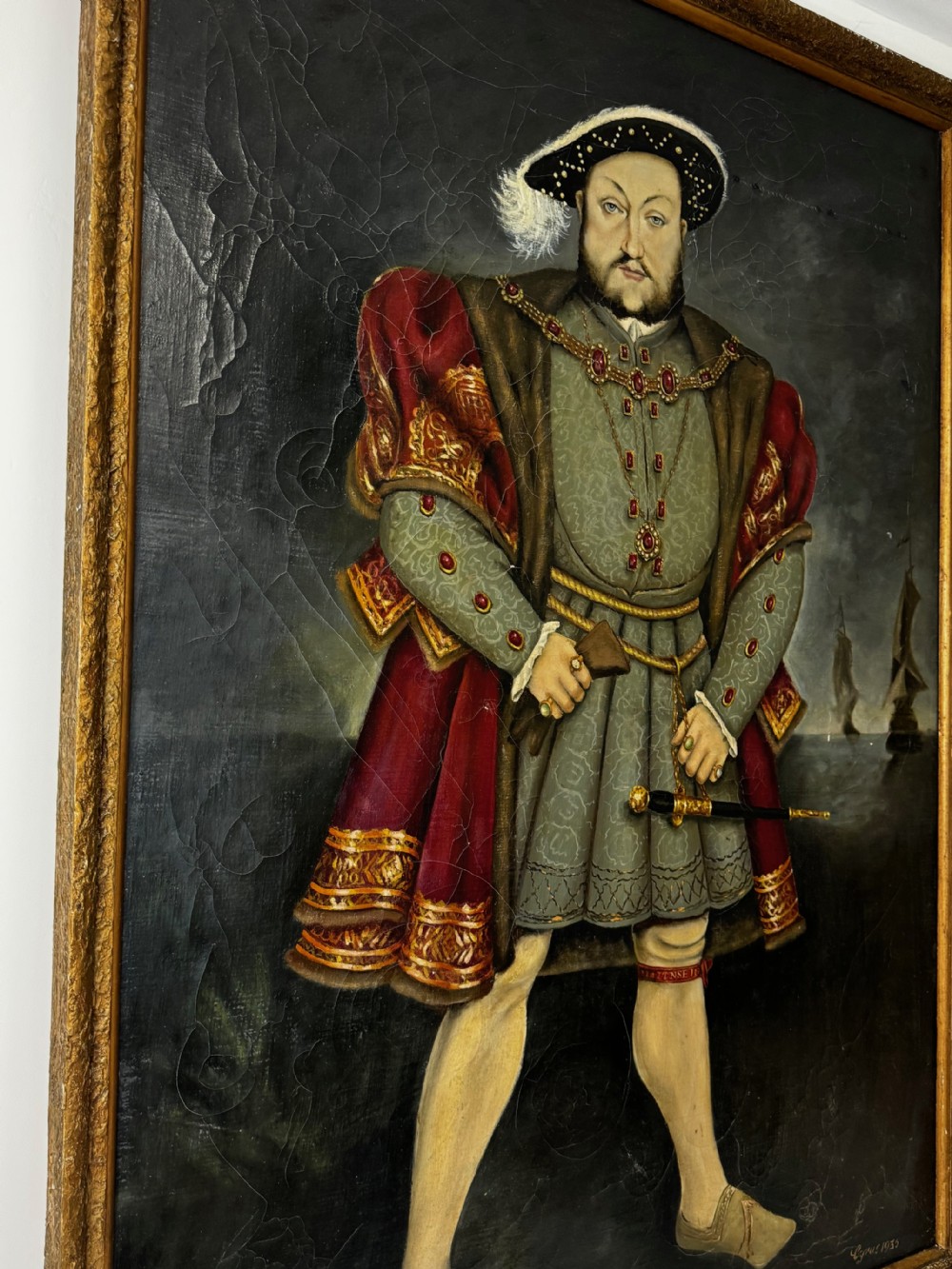 A large oil painting in a gilded frame depicting King Henry VIII standing in Tudor costume with jewels, dagger, and feathered cap against a dark backdrop. View III