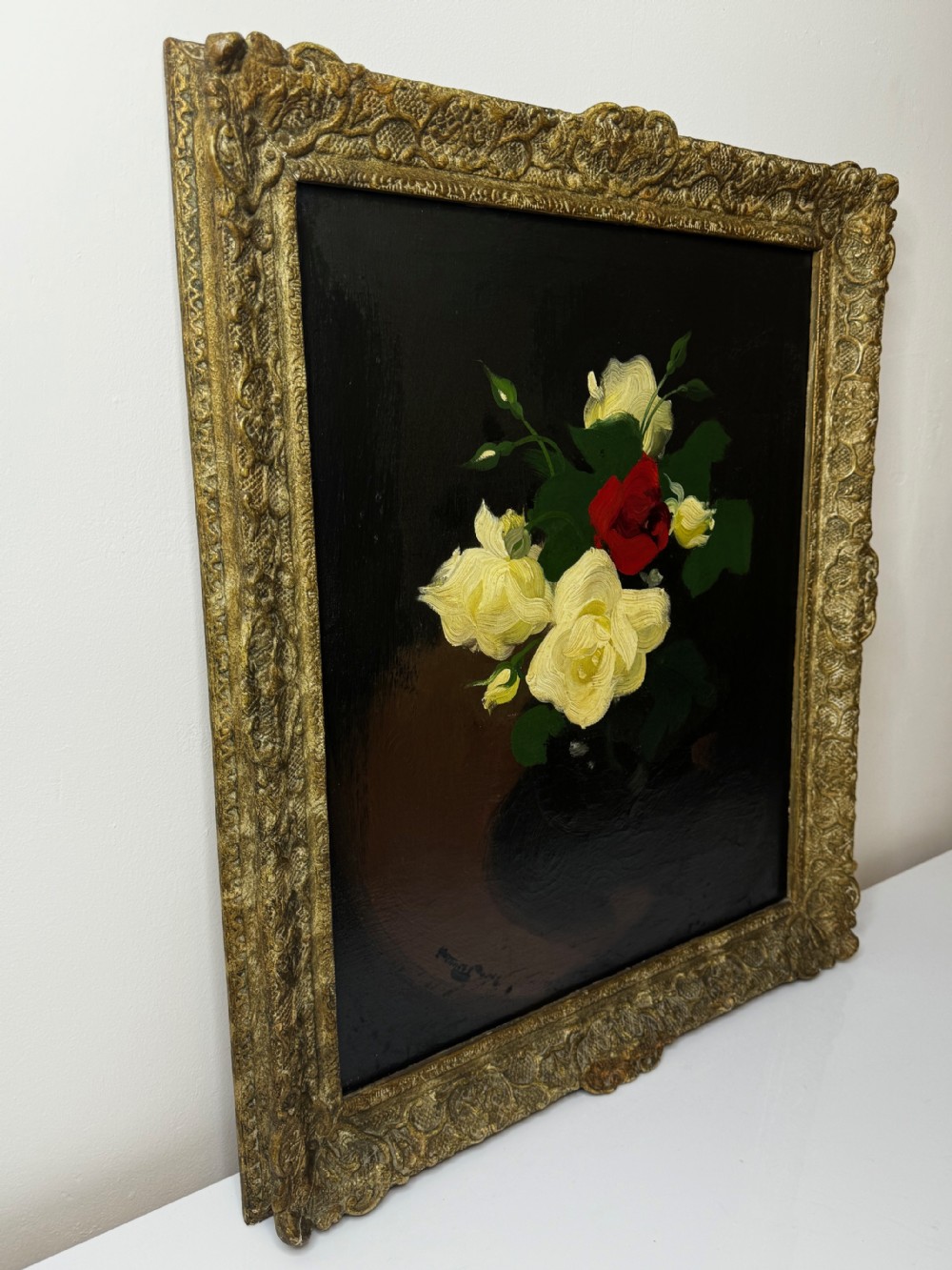 A Victorian floral oil painting depicting yellow and red roses against a dark background, set within a heavy, ornate gold gilded frame. View X