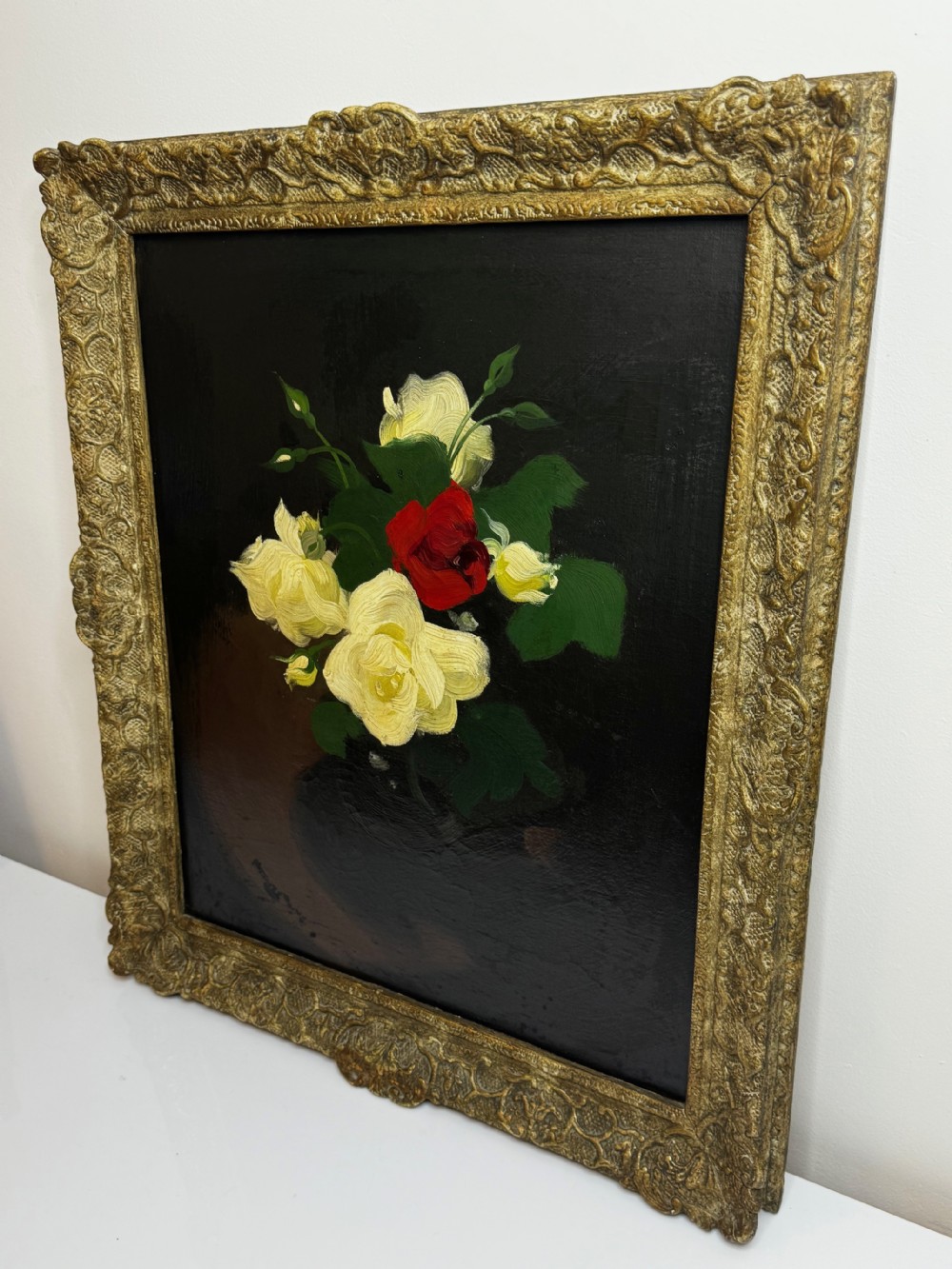 A Victorian floral oil painting depicting yellow and red roses against a dark background, set within a heavy, ornate gold gilded frame. View XI