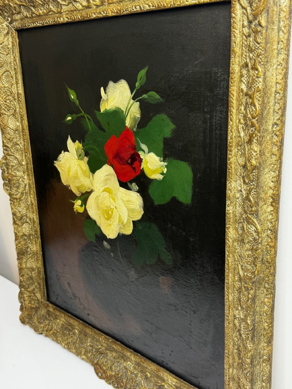 A Victorian floral oil painting depicting yellow and red roses against a dark background, set within a heavy, ornate gold gilded frame. View XII