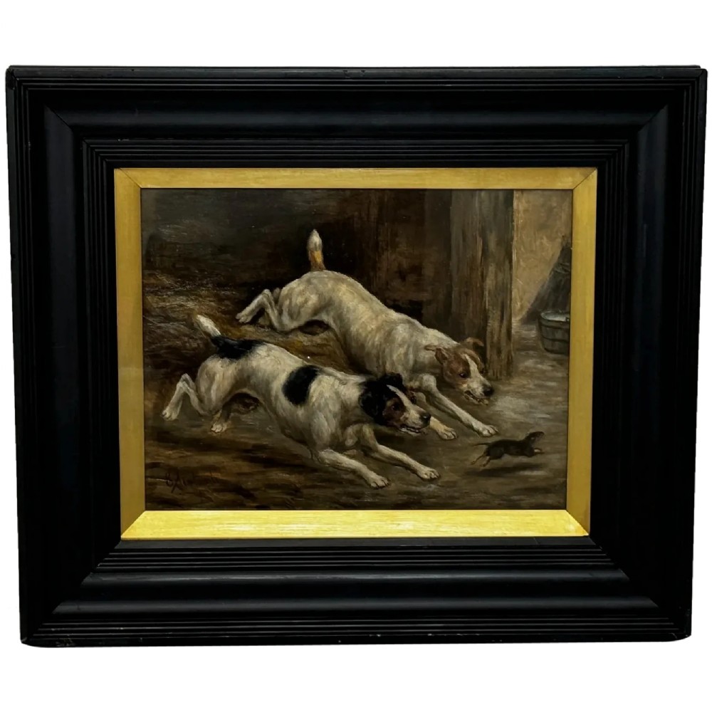 A Victorian oil painting framed in ebonised timber and a gilt slip, depicting two white and dark-marked terriers pursuing a rat inside a barn.