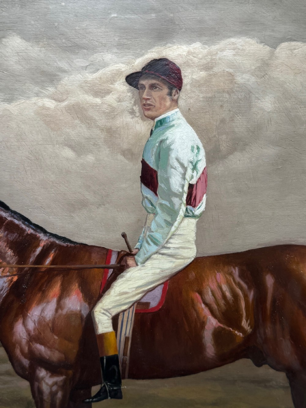A nineteenth-century oil painting depicting a brown thoroughbred horse with a jockey in white and red silks, framed in a ribbed gold-leaf frame. View XXX