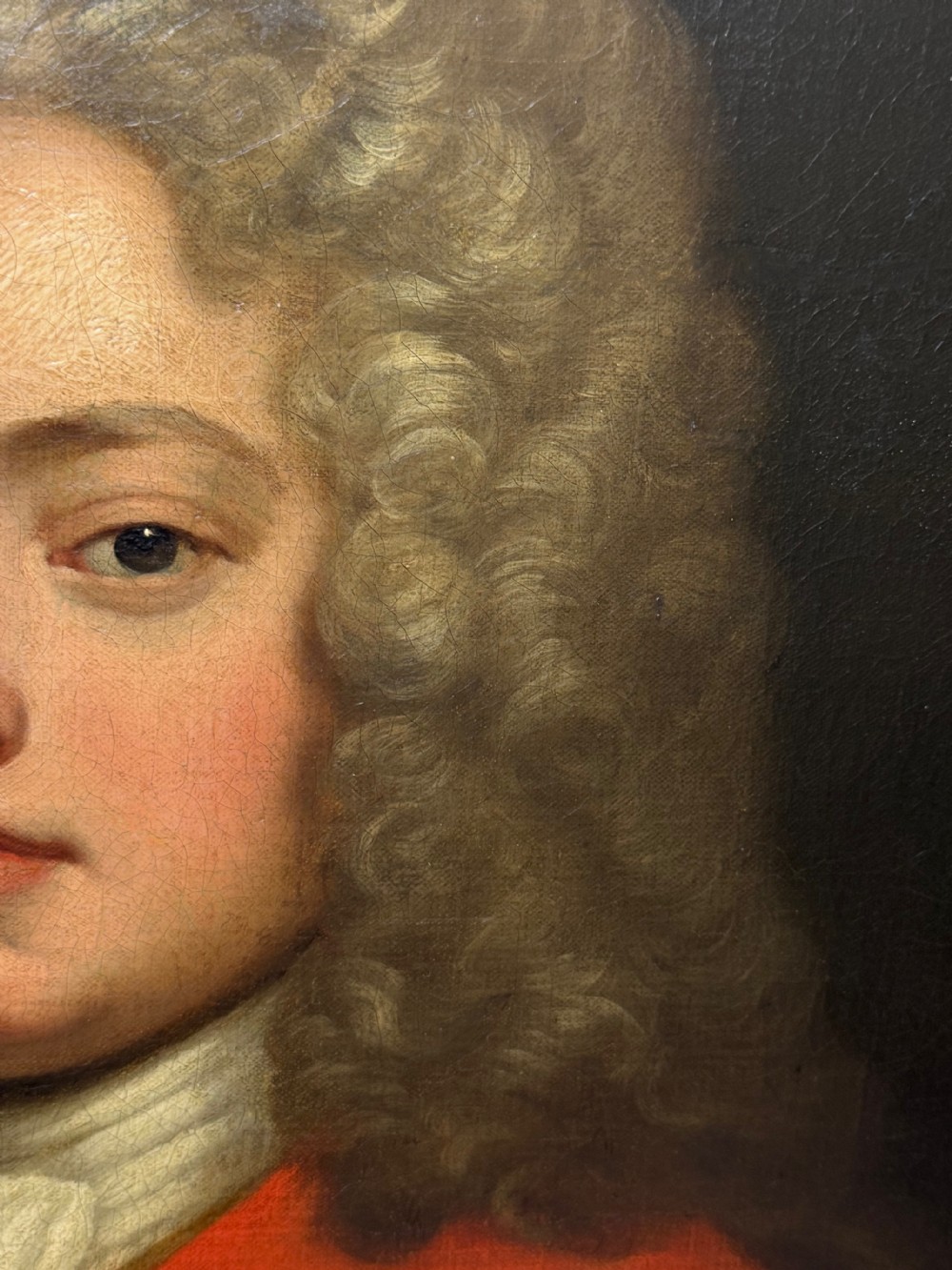An 18th-century oil portrait painting depicting a gentleman in a red coat and white cravat housed within a moulded giltwood frame. View XX