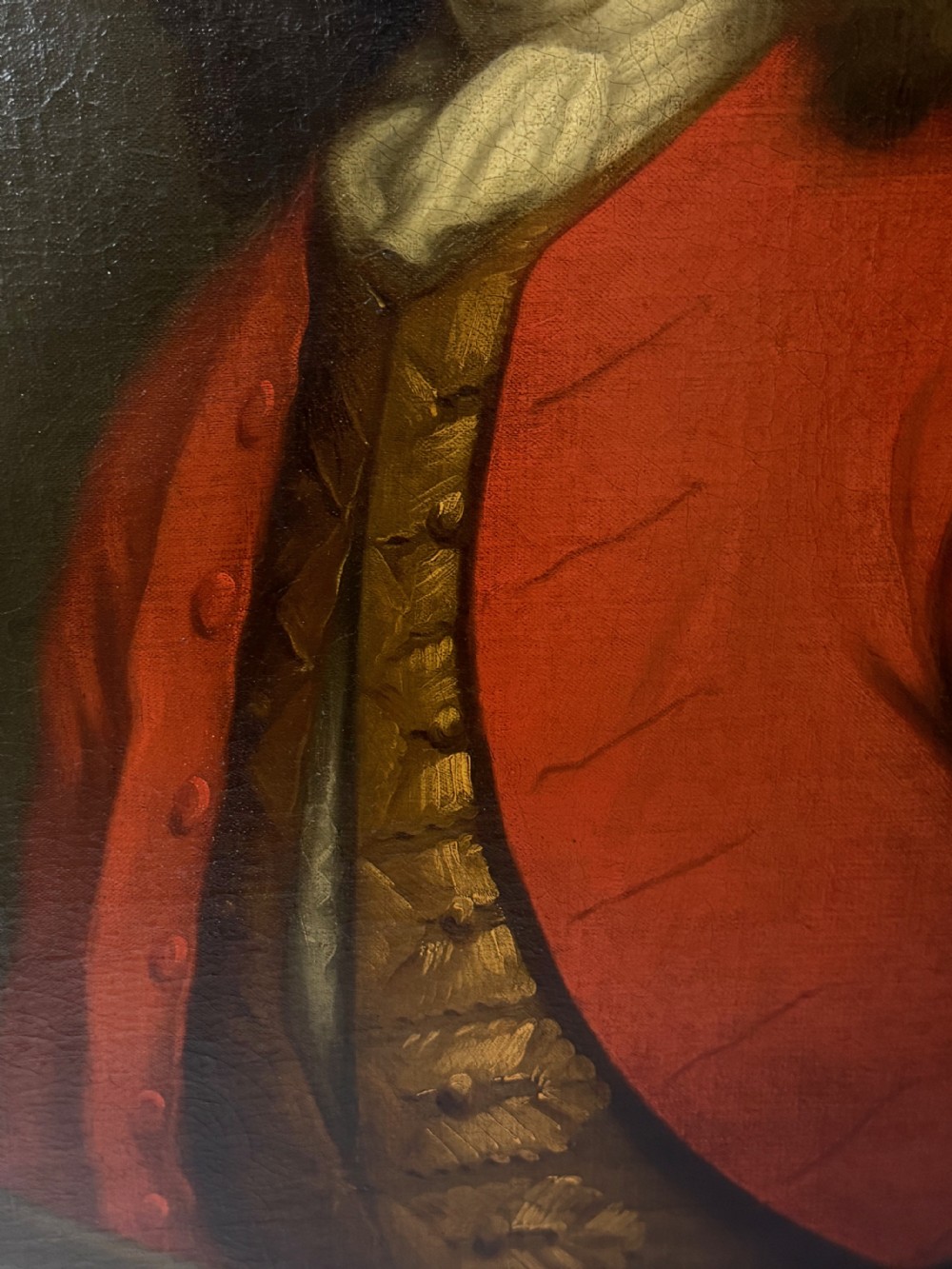 An 18th-century oil portrait painting depicting a gentleman in a red coat and white cravat housed within a moulded giltwood frame. View XXV