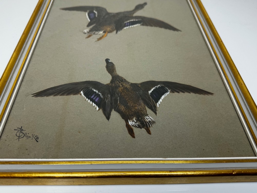 A vertical framed Victorian oil painting by Thomas Blinks depicting two mallard ducks flying upward against a plain grey background. View VIII