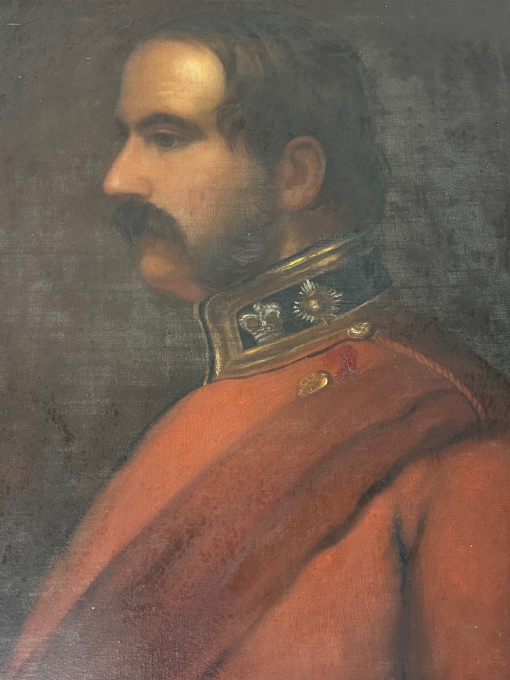 A profile view Victorian oil painting depicting a military officer with a moustache in a red uniform coat, set within a gilded wooden frame. View XXV