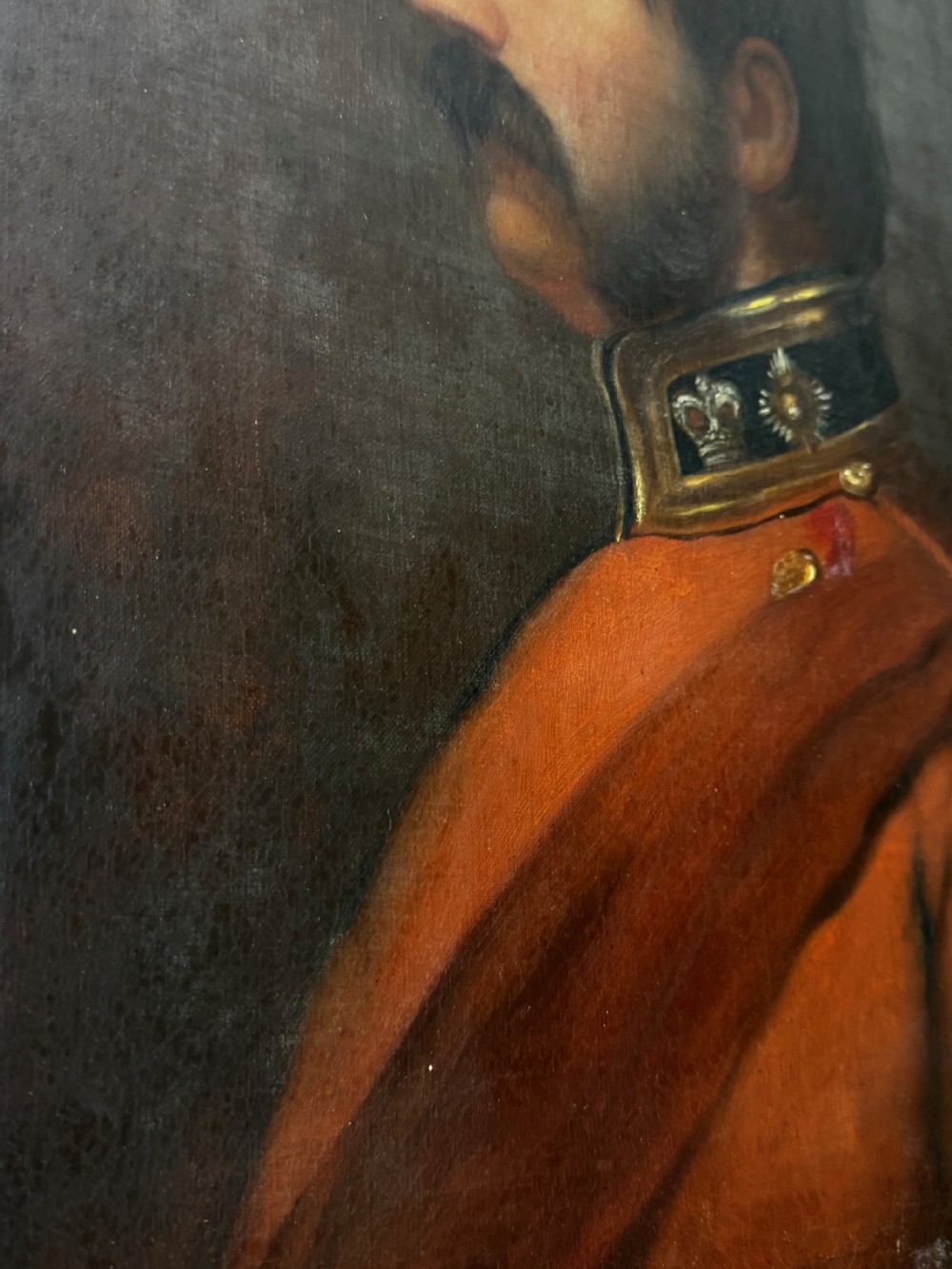A profile view Victorian oil painting depicting a military officer with a moustache in a red uniform coat, set within a gilded wooden frame. View XXX