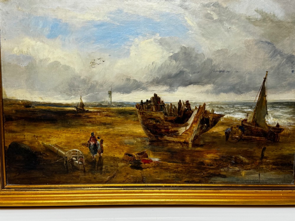 An antique oil painting depicting a grounded wooden ship wreck on a sandy shoreline with a distant lighthouse, set in a gold gilded frame. View III