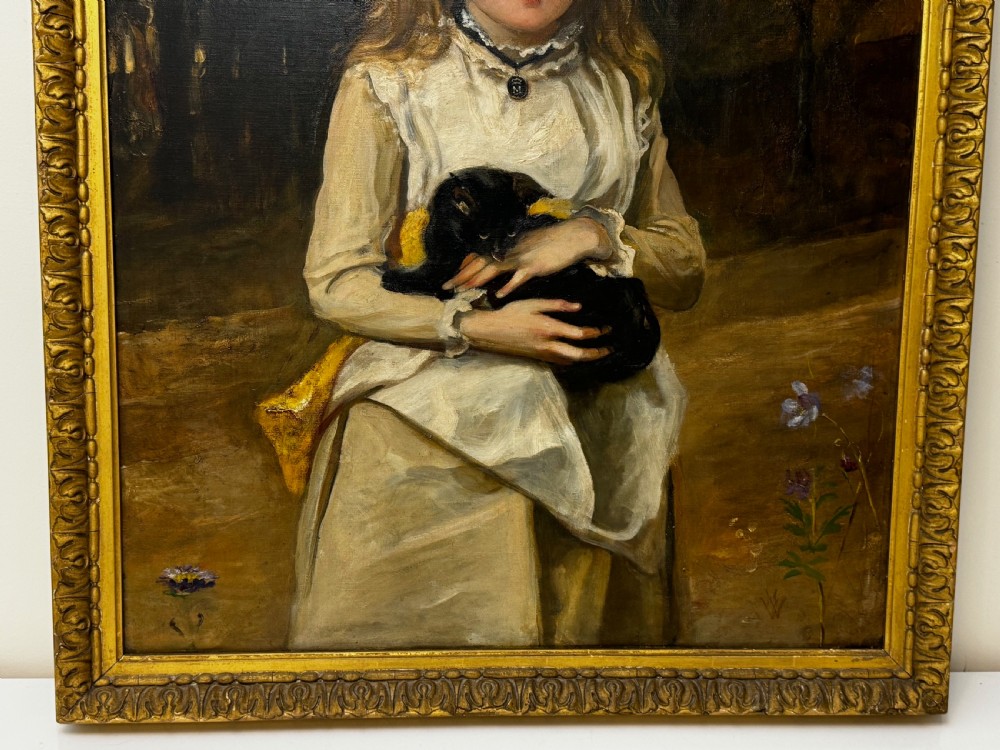 A Victorian oil portrait on canvas depicting a young girl with blonde hair holding a black cat, presented in a carved gold-coloured frame. View IV
