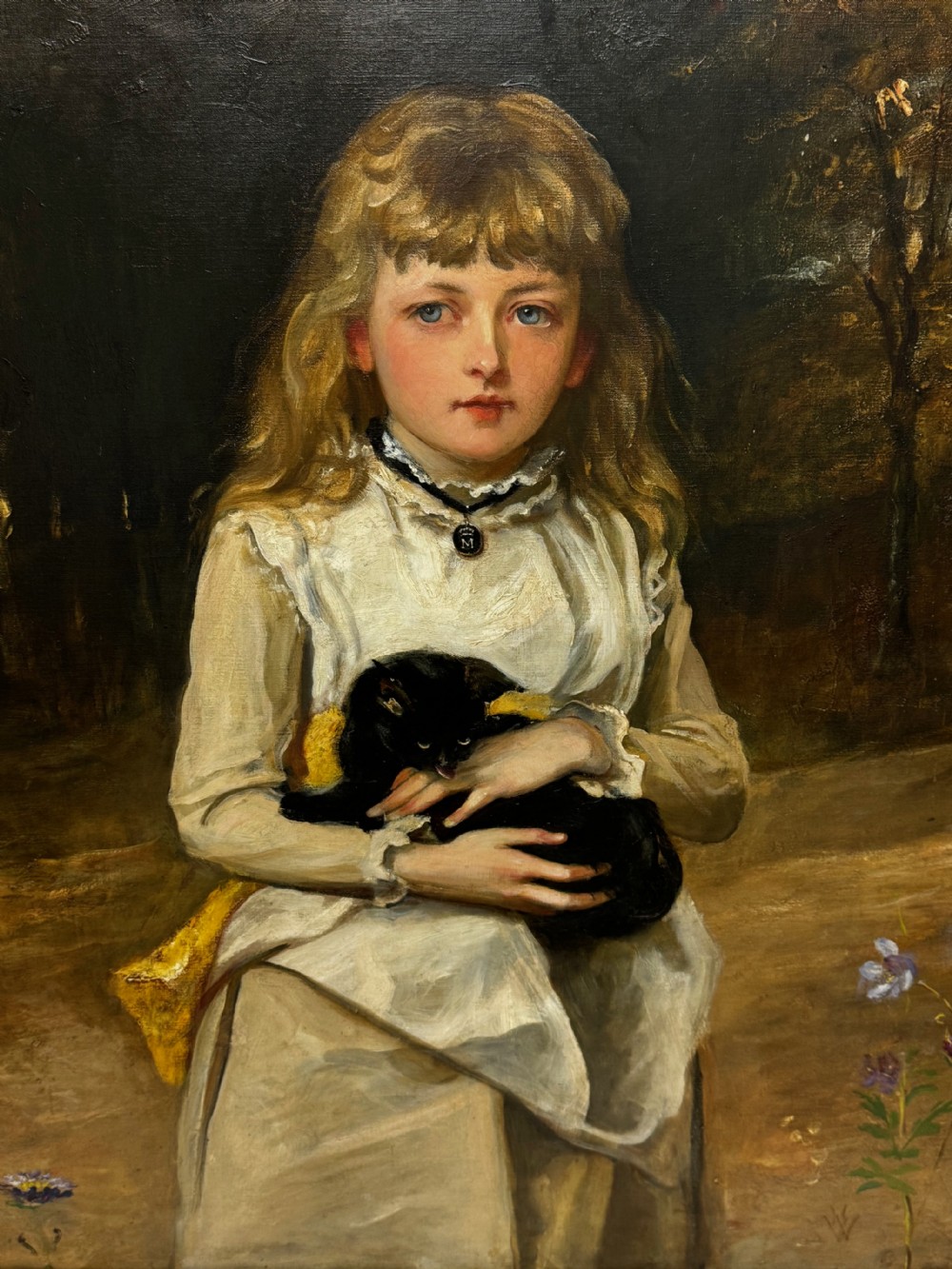 A Victorian oil portrait on canvas depicting a young girl with blonde hair holding a black cat, presented in a carved gold-coloured frame. View VI