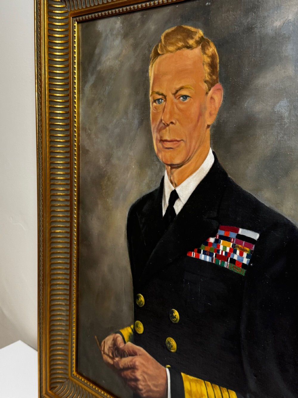 A framed oil painting depicting King George VI in a dark naval uniform with medal ribbons and gold sleeve braid against a grey background. View III