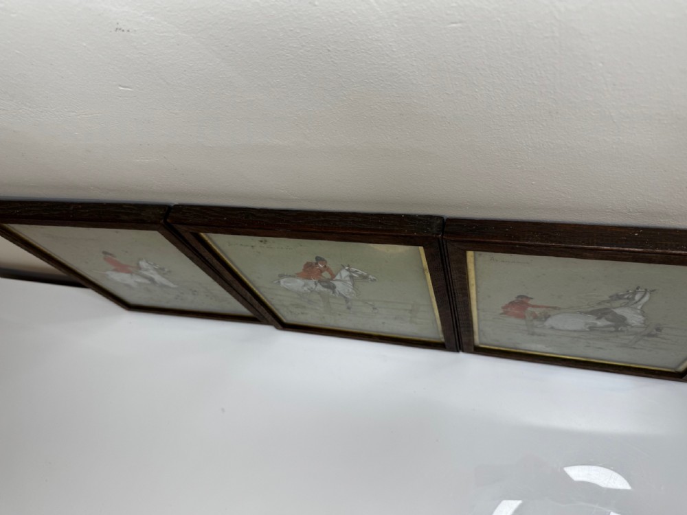 A set of three framed equestrian artworks by Snaffles depicting horse riders in red coats navigating rustic timber fences. View XVII