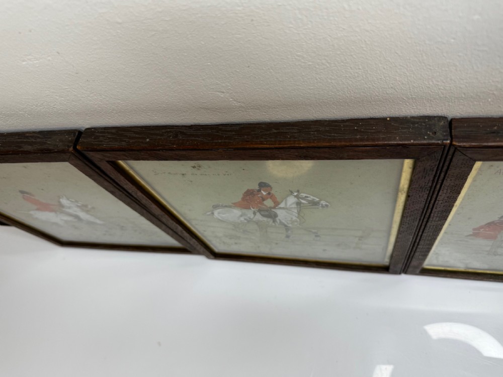 A set of three framed equestrian artworks by Snaffles depicting horse riders in red coats navigating rustic timber fences. View XVIII