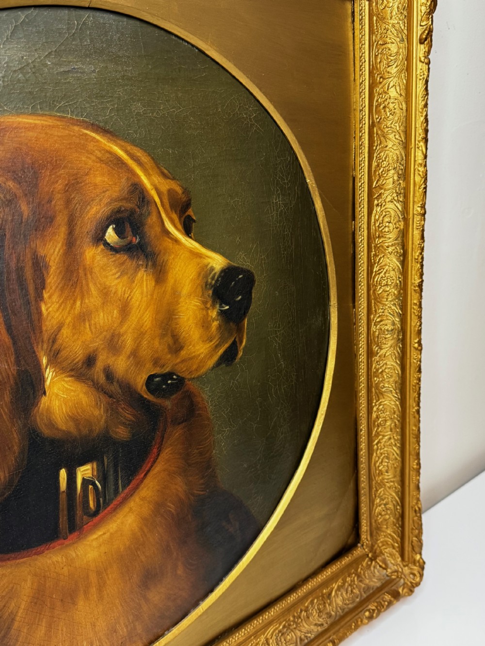 A Victorian oil painting depicting the head profile of a brown hound set inside a circular aperture within a heavy gold gilt frame. View VIII