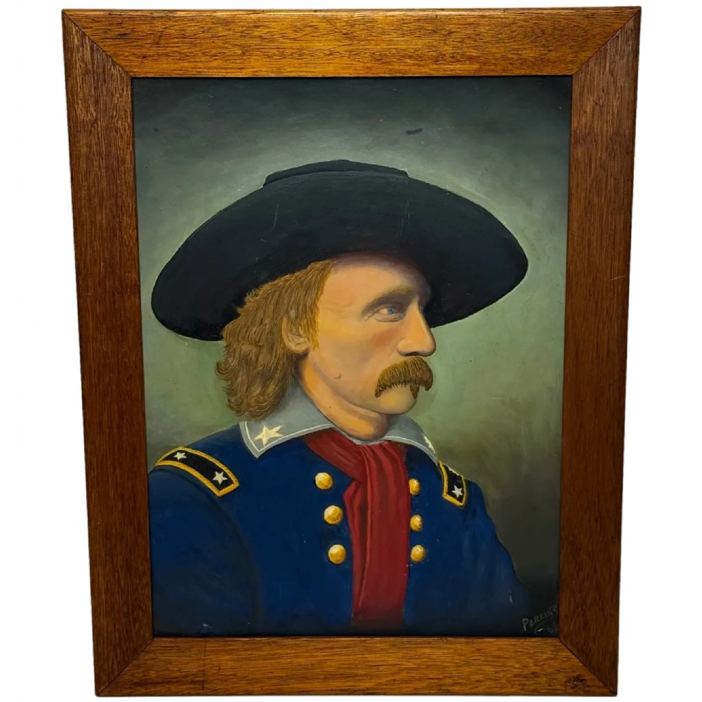 A framed oil painting portraying General George Custer in profile wearing a blue uniform with gold stars and a black hat.
