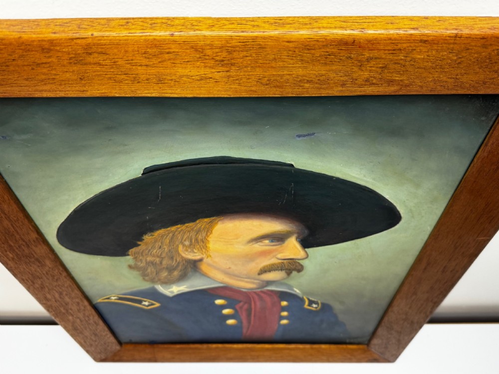 A framed oil painting portraying General George Custer in profile wearing a blue uniform with gold stars and a black hat. View X