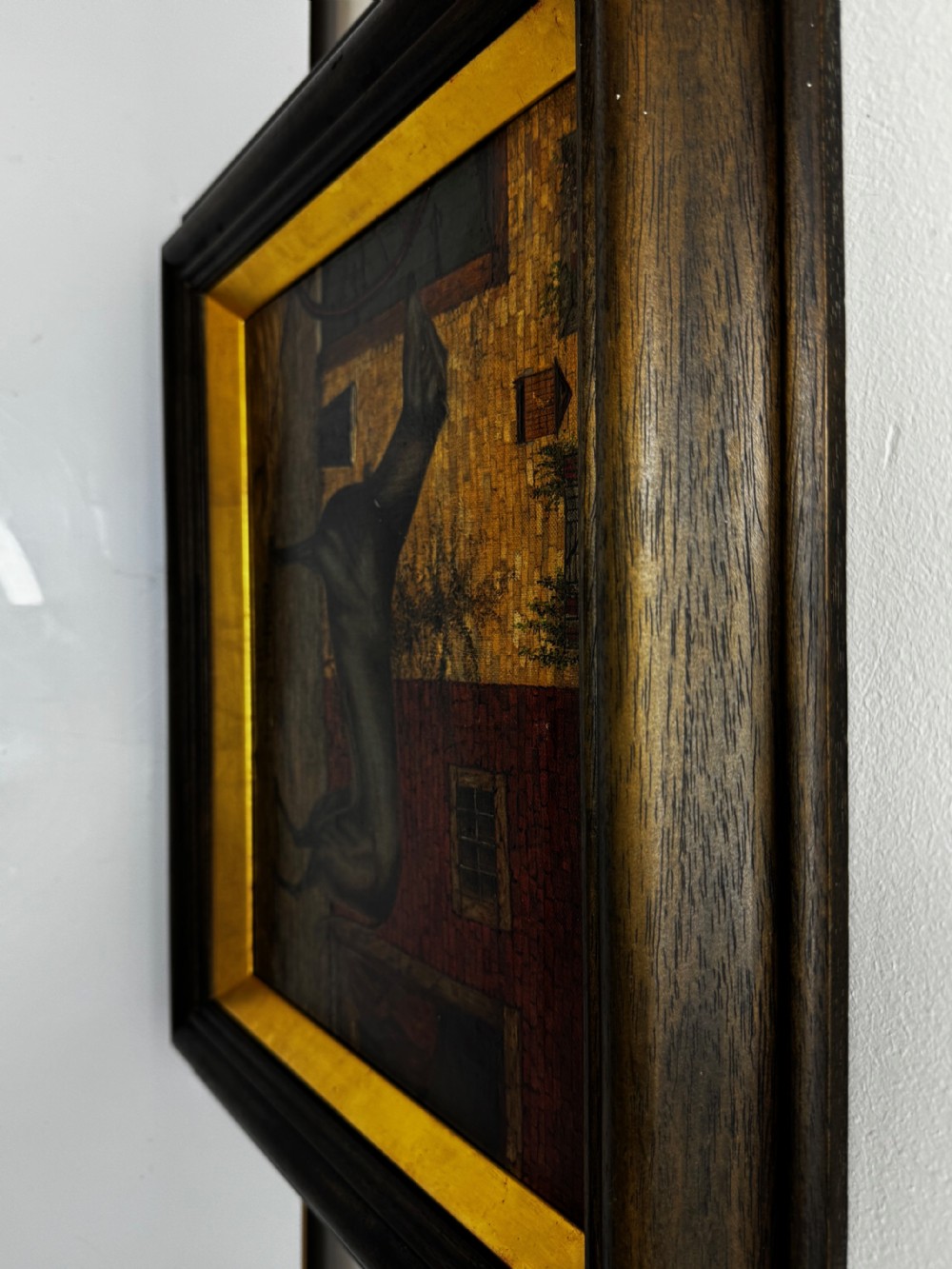 A Victorian oil painting depicting a dark brown greyhound standing in profile within a courtyard, presented in a dark molded wooden frame with a gold slip. View V