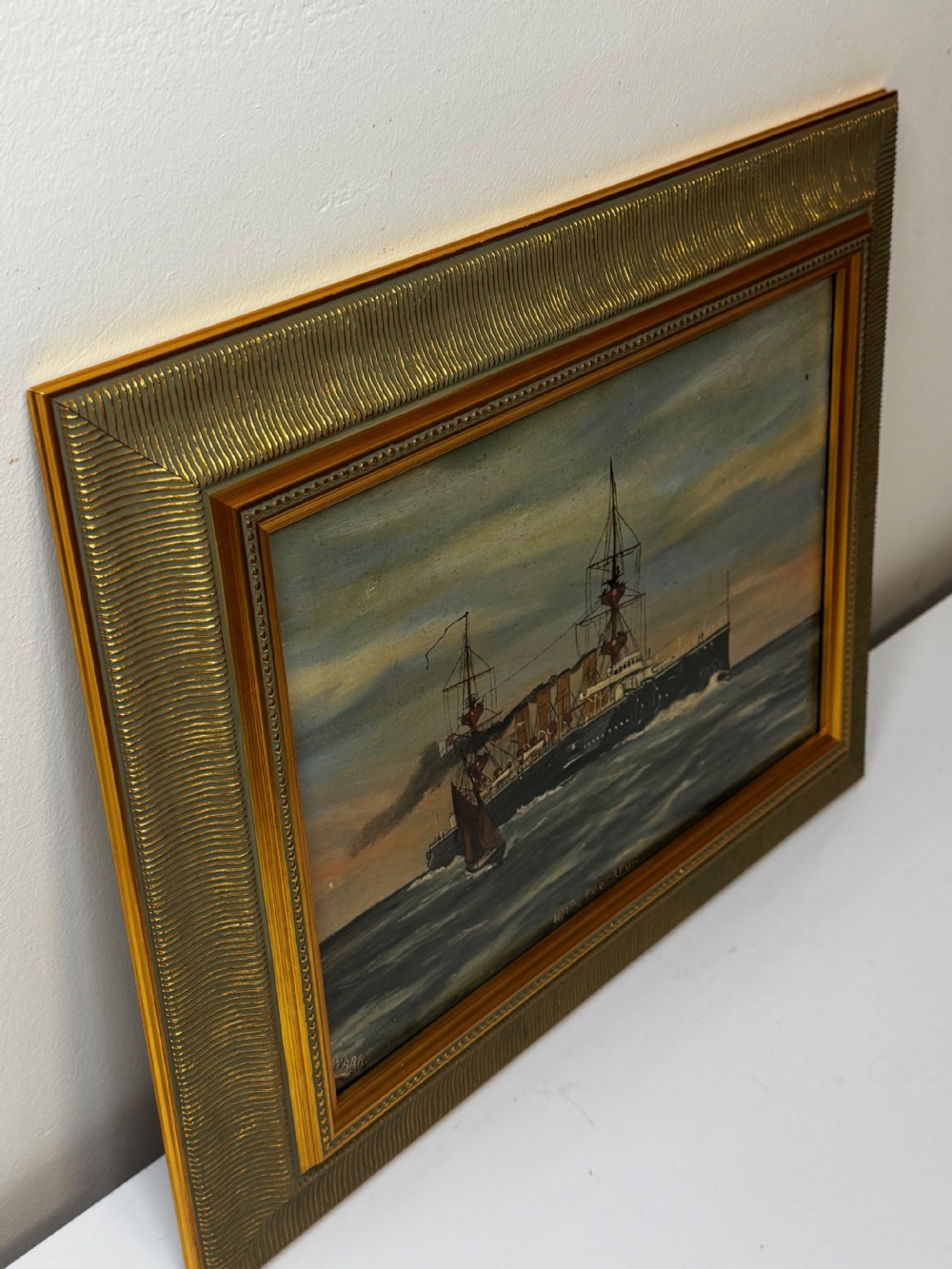 An oil painting depicting the Royal Navy cruiser HMS Powerful sailing across open waters with smoke billowing from its funnels under a sunset sky, housed in a gilt frame. View VII