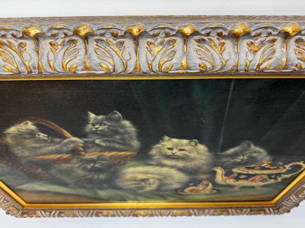 A framed oil painting featuring six fluffy grey and silver Persian kittens arranged around a woven basket and a decorated porcelain teapot. View XII