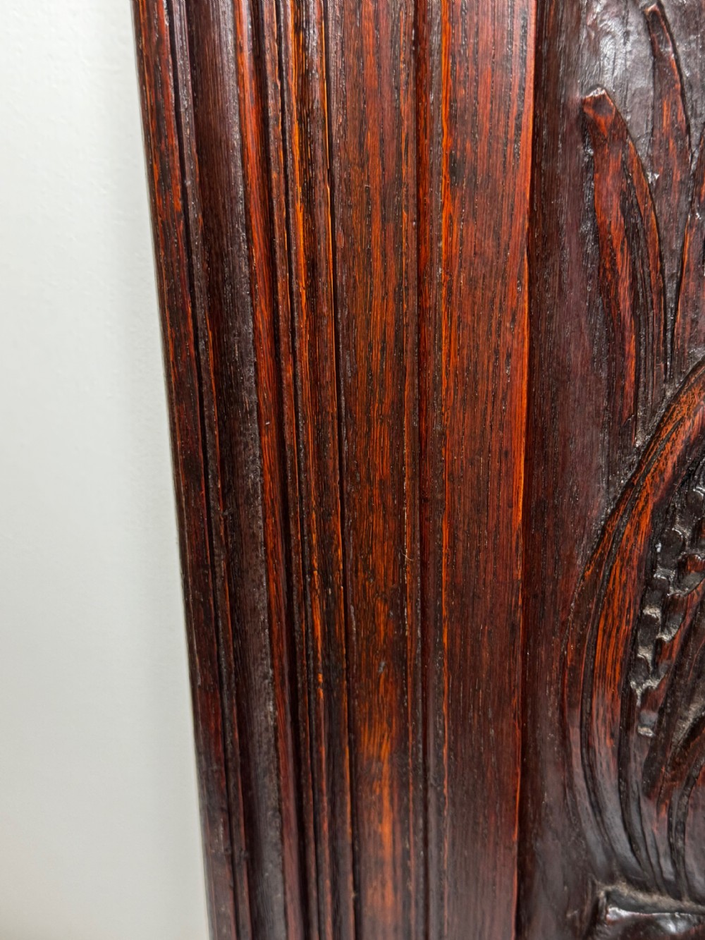 A dark oak relief carving depicting a game bird standing among reeds and oak leaves with acorns inside a moulded frame. View XXVIII