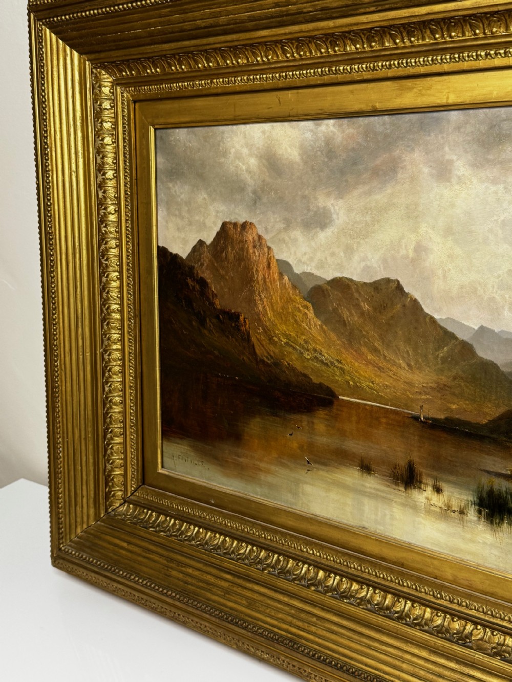 A Victorian landscape oil painting depicting Lake Windermere with mountains in the background, set within a heavy multi-moulded gold frame. View V