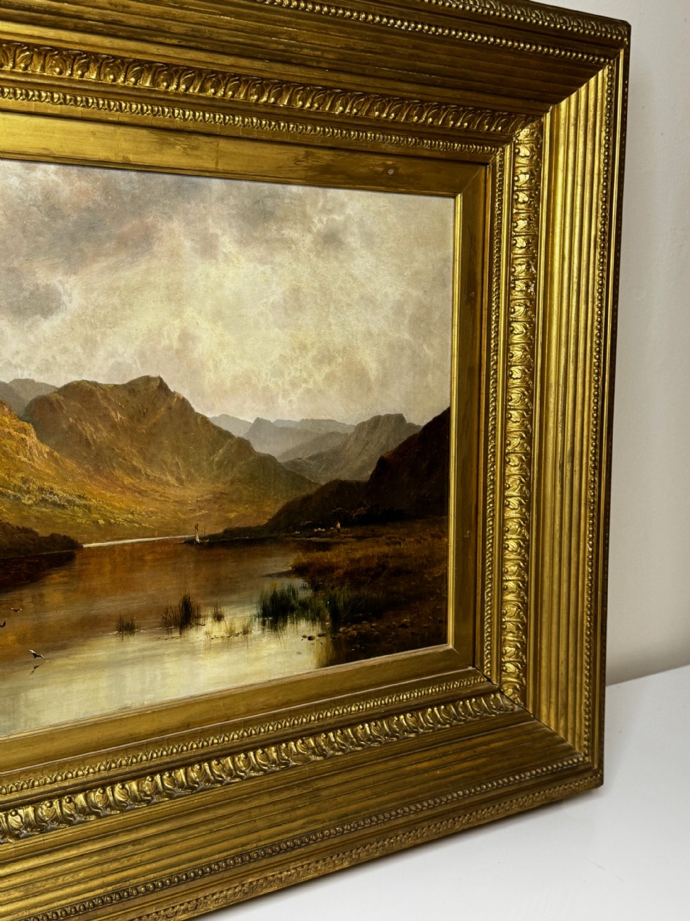 A Victorian landscape oil painting depicting Lake Windermere with mountains in the background, set within a heavy multi-moulded gold frame. View VI