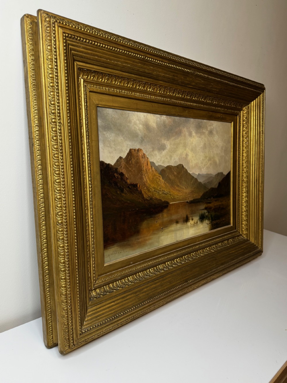 A Victorian landscape oil painting depicting Lake Windermere with mountains in the background, set within a heavy multi-moulded gold frame. View IX