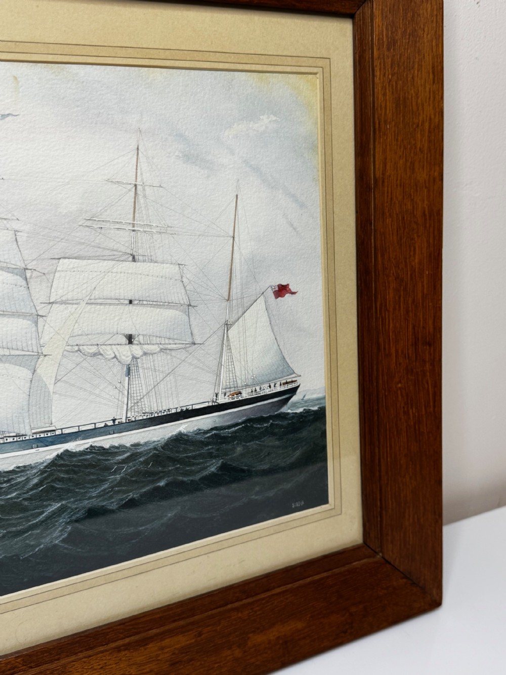 A framed maritime painting depicting a four-masted barque sailing ship on choppy water set within a light card mount and a wide wooden frame. View VIII