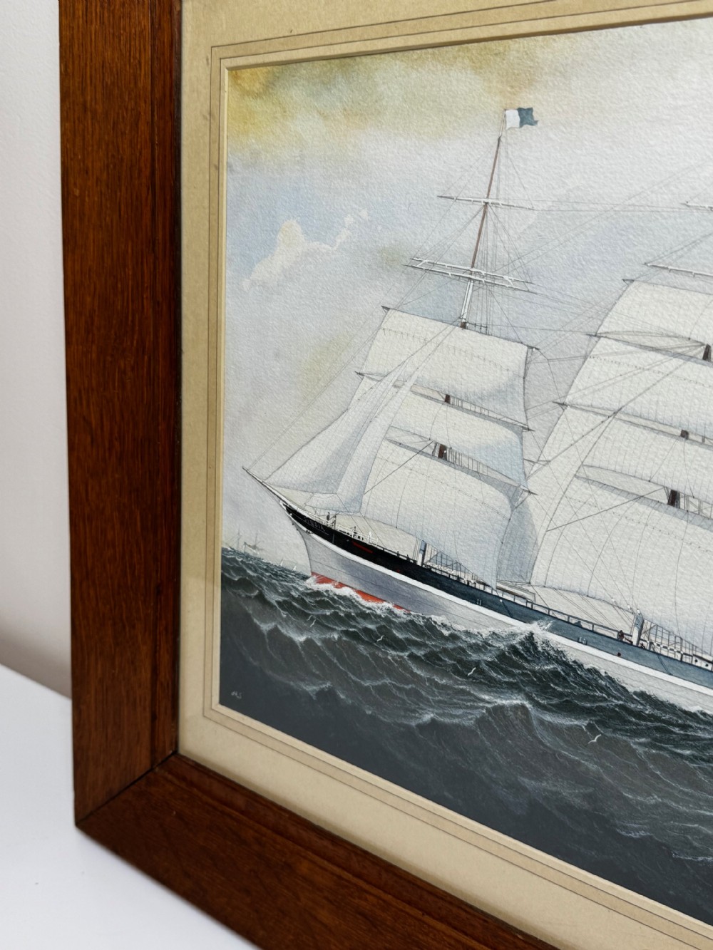A framed maritime painting depicting a four-masted barque sailing ship on choppy water set within a light card mount and a wide wooden frame. View IX