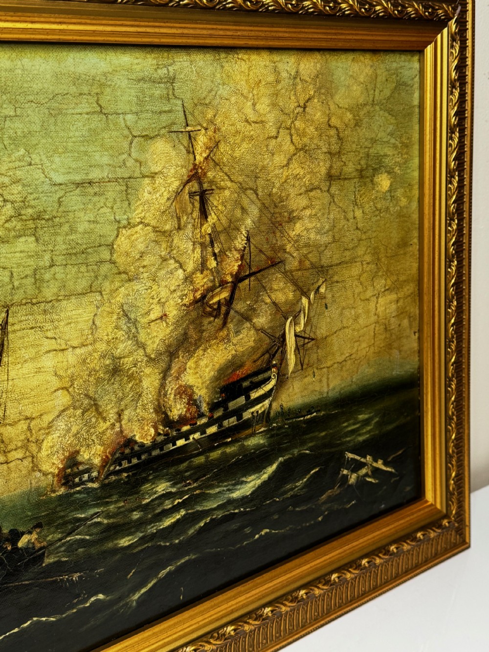 A framed 19th-century style maritime oil painting on canvas depicting a ship engulfed in flames on choppy seas, set within an ornate gilded frame. View VI