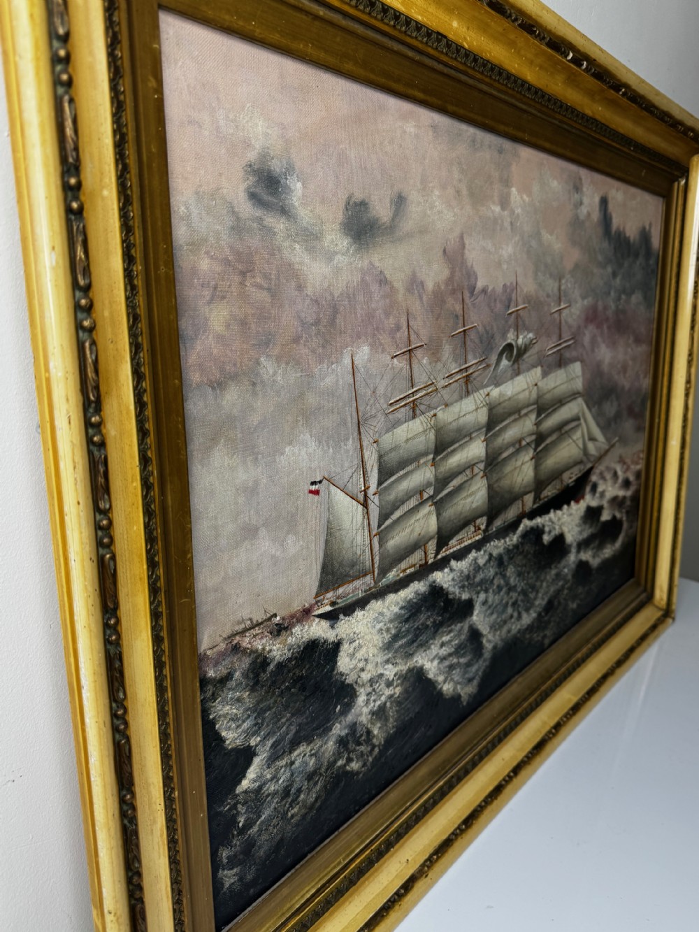 An oil painting depicting a five-masted vessel named Potosi sailing through turbulent ocean waves under a grey sky, enclosed in a gilded frame. View VII
