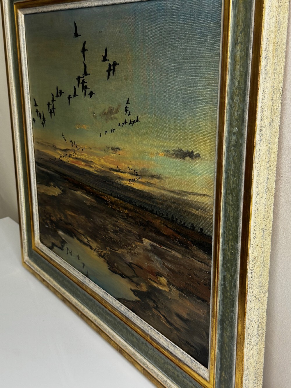 Framed oil painting depicting a skein of geese in flight over coastal marshlands at dusk. View VII