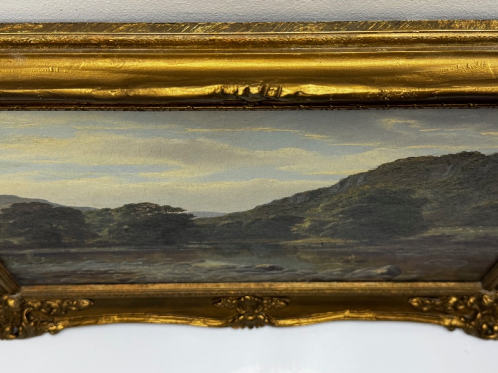 A 19th-century Victorian oil painting depicting a river running through a mountainous Welsh landscape, enclosed in an ornate gold gilt frame. View VII
